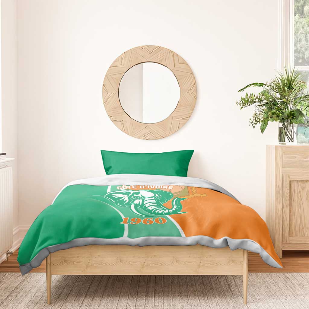 Green and orange Cote d'Ivoire elephant duvet with two pillowcases on wooden bed