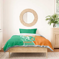 Green and orange Cote d'Ivoire elephant duvet with two pillowcases on wooden bed