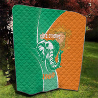 Green and orange quilt with elephant emblem, Cote d'Ivoire text and 1960, on grass