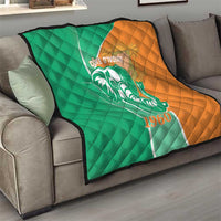 Green and orange quilt draped on sofa with elephant emblem and 1960