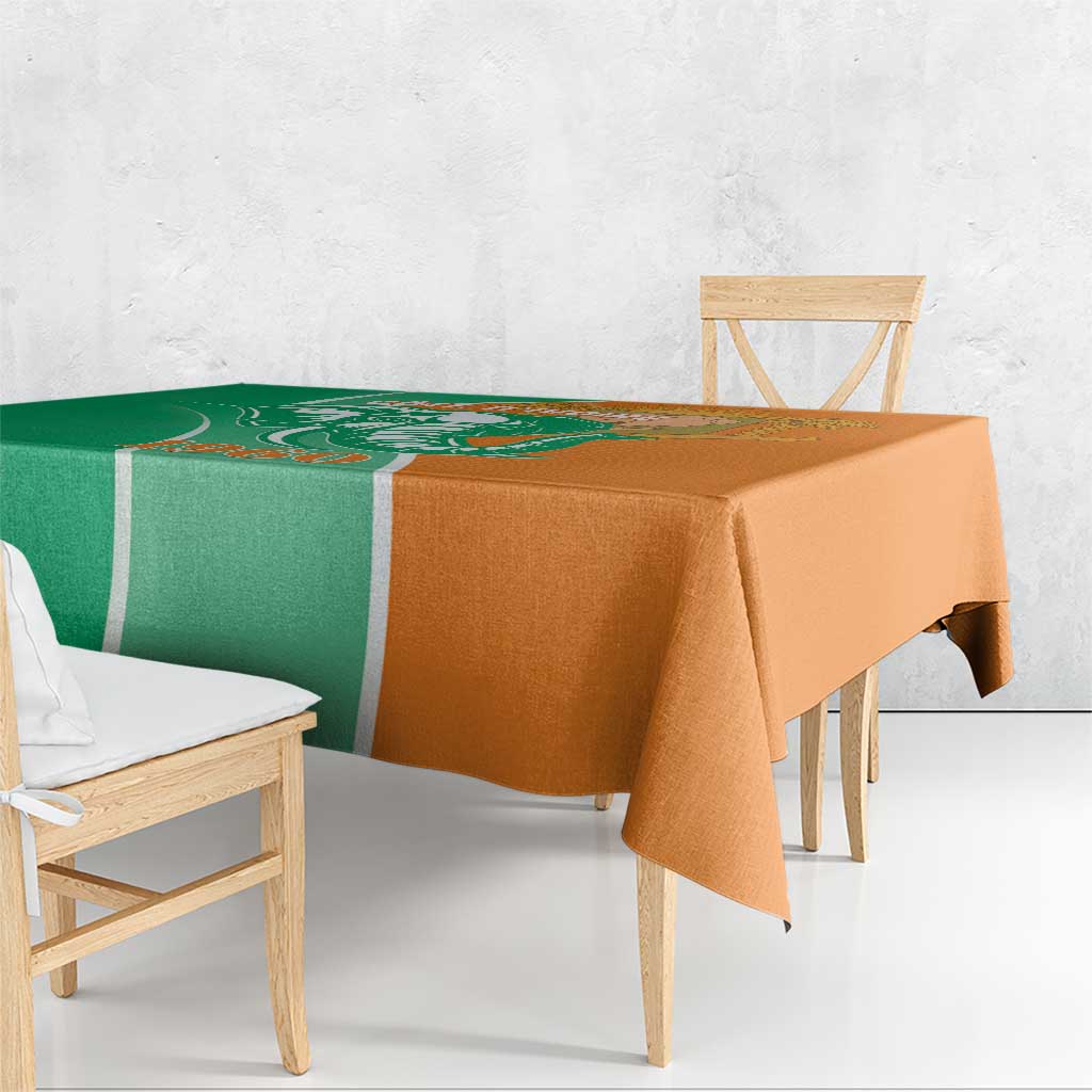 Two-tone green and orange tablecloth draped over a dining table, corner hanging