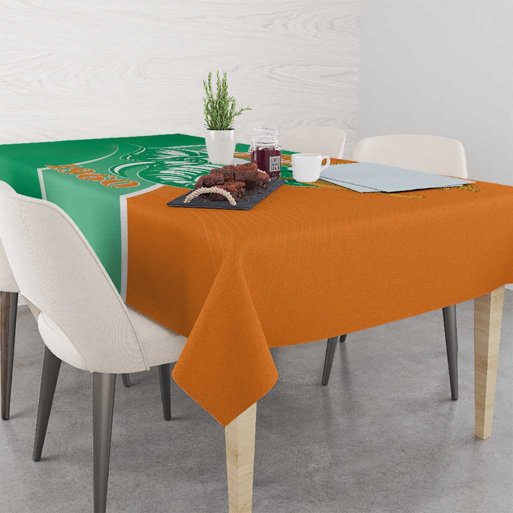 Two-tone green and orange tablecloth on dining table with small centerpiece items