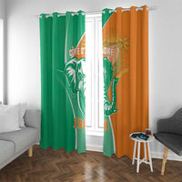Two hanging window curtains, green left and orange right, elephant emblem and flag design