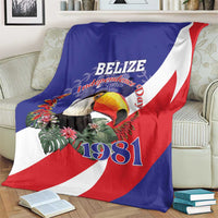 Belize Independence Day 1981 blanket on couch, blue/red/white flag with toucan and 1981
