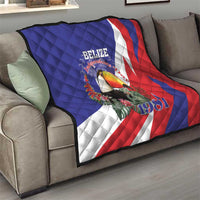 Blue red and white Belize Independence 1981 quilt draped on sofa, toucan graphic centered.