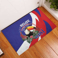 Blue rubber doormat on wooden floor with toucan, leaves, and Belize 1981 print