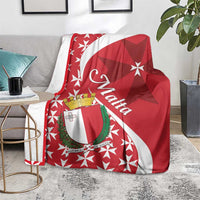 Red Malta themed blanket draped over couch showing Maltese cross star pattern and shield