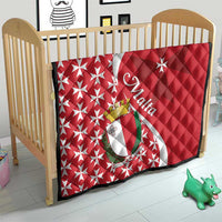 Malta quilt laid on crib, red and white Maltese cross with star pattern and emblem