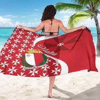 Red sarong laid flat showing white star pattern and Maltese cross crest