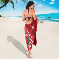 Red sarong wrap worn with Maltese cross emblem and white star details