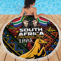 Round fringed beach blanket featuring South Africa Heritage Day 1995 text and springbok