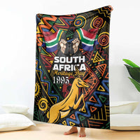 Black South African Heritage Day blanket with colorful springbok and tribal pattern, draped.