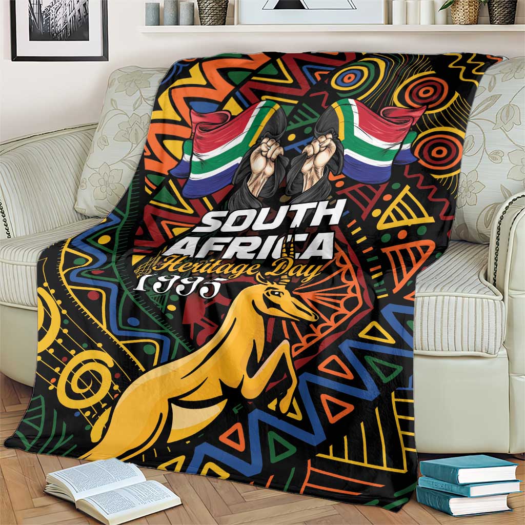 Black blanket over couch with colorful African geometric pattern, springbok and Heritage Day 1995.