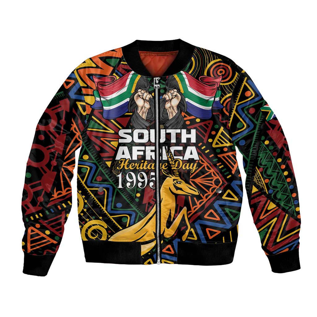 Black bomber jacket with colorful African pattern, front zip, ribbed cuffs, springbok graphic