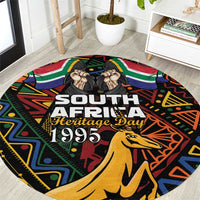 Black round carpet with 'South Africa Heritage Day 1995' and springbok illustration
