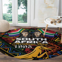 Black round carpet showing South Africa Heritage Day 1995 text and springbok figure