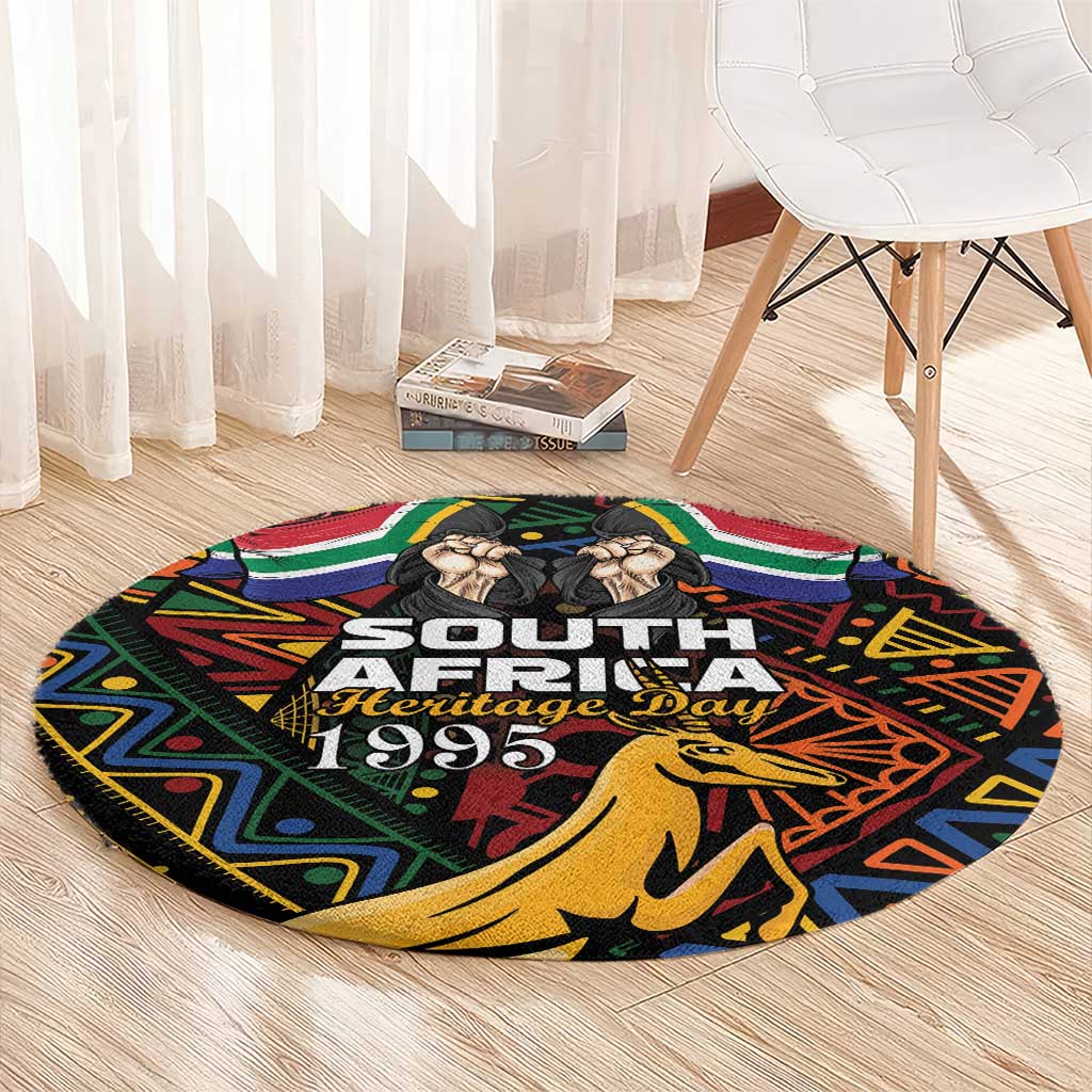 Black round rug with South Africa Heritage Day 1995 print and springbok graphic
