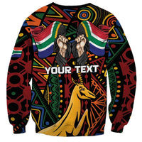 Black unisex sweatshirt with colorful geometric pattern and 'YOUR TEXT' springbok graphic