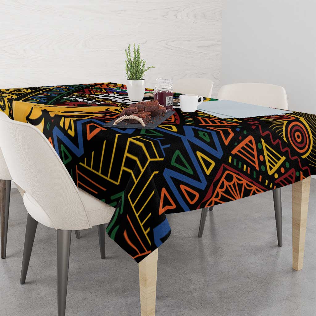 Black tablecloth with bold African geometric pattern, draped across table with place settings