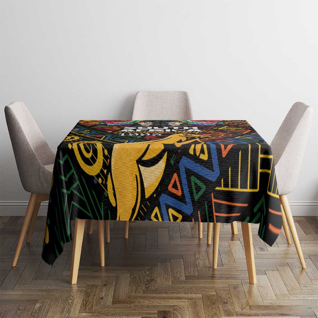 Black tablecloth with colorful African geometric and tribal-style motif, covering dining table