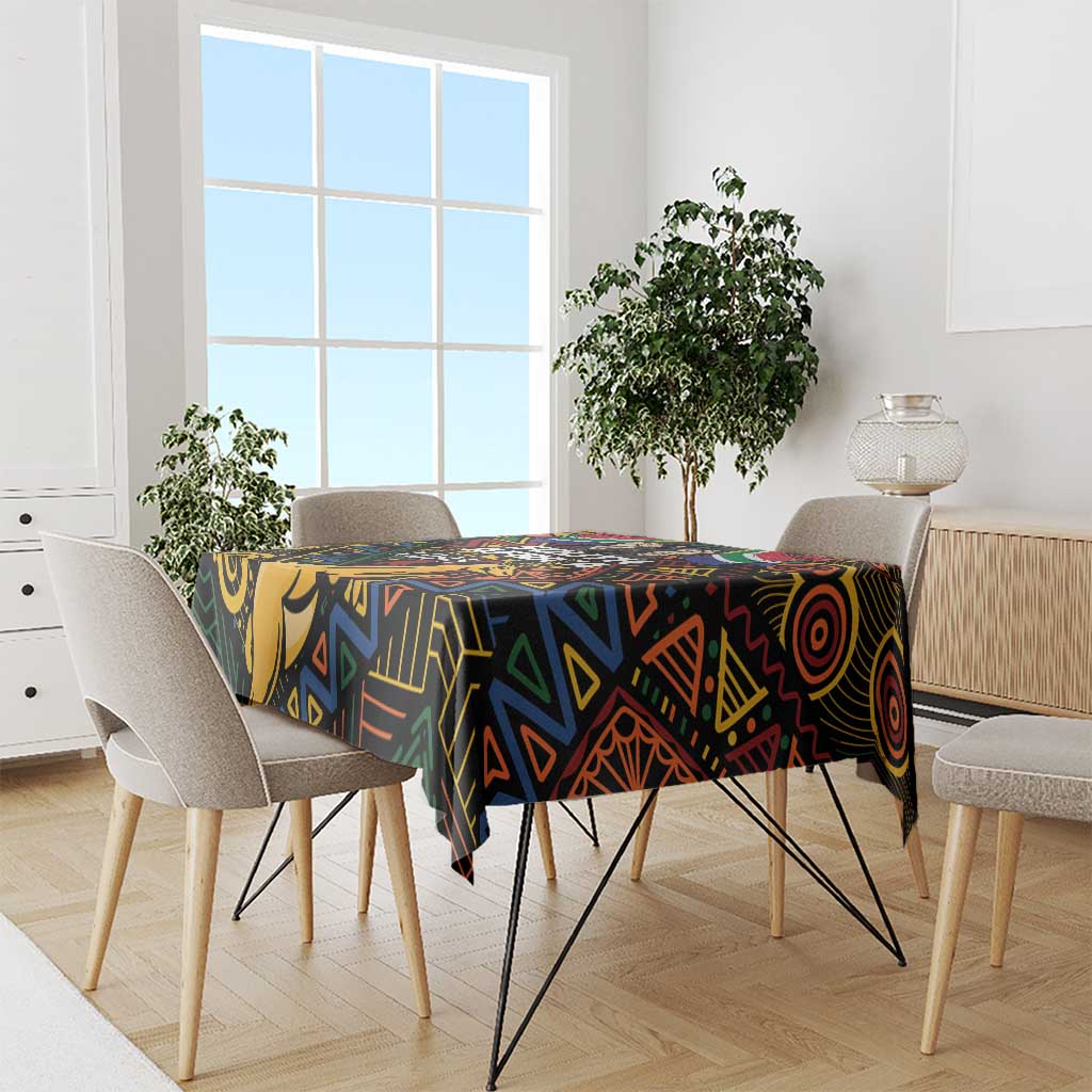 Black tablecloth with vivid African geometric pattern, set on dining table with chairs