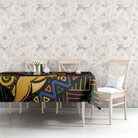 Black tablecloth with colorful African geometric print, laid across table in a dining room