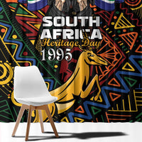 Close-up view of African-pattern window curtain with bold “South Africa Heritage Day 1995” text