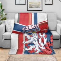 Red, blue and white Czech lion graphic blanket on a gray sofa