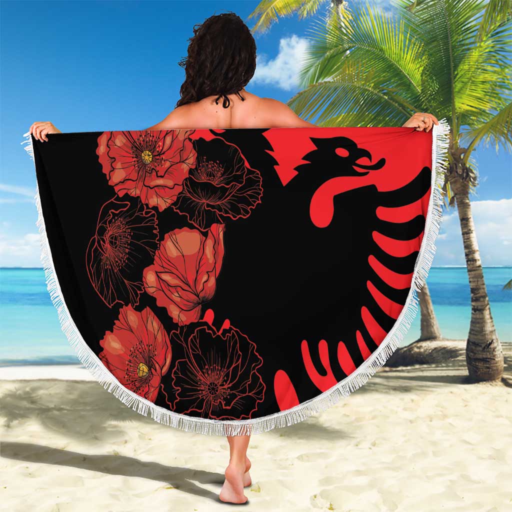 Round red beach blanket with black floral pattern and eagle graphic, fringed edge