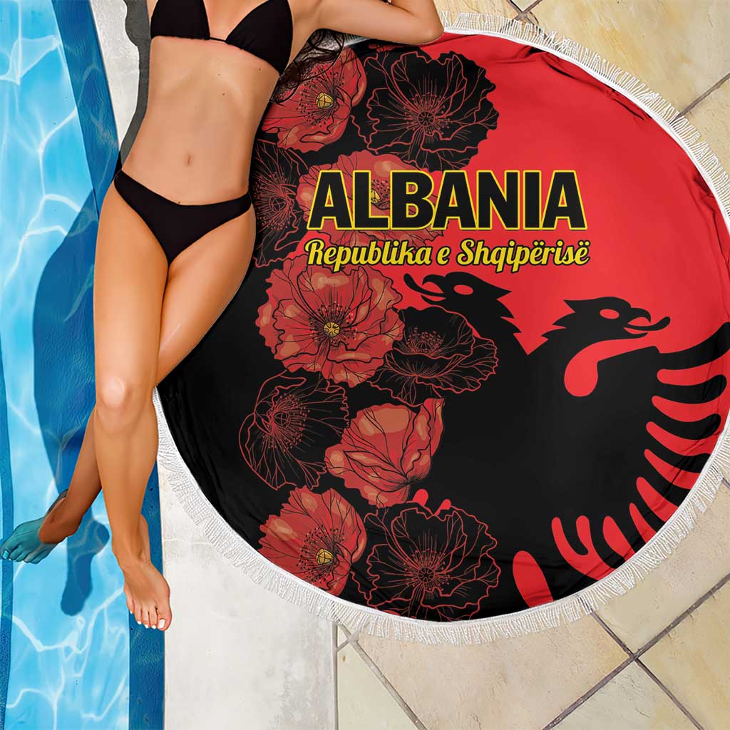 Red round beach blanket with black floral and eagle graphics, white fringed border