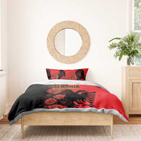 Red and black duvet cover with poppy floral print and Albanian eagle emblem, styled on bed