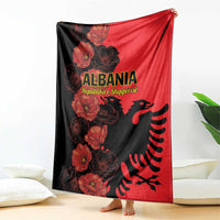 Albania-themed blanket draped on floor, red and black with floral eagle print