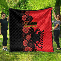 Two-tone quilt blanket with black left and red right, Albania crest and floral design.