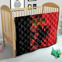 Quilt blanket for baby bed, black and red halves with Albania emblem, floral, quilted texture.