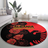 Red and black Albania round carpet on living room floor, floral eagle design