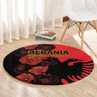 Red and black round Albania carpet with floral poppies and eagle emblem on wood