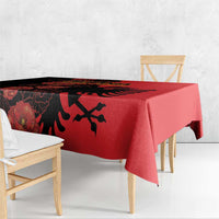 Red tablecloth with black floral patterns and eagle motif, draped over dining table