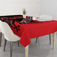 Red and black floral tablecloth with eagle emblem across the tabletop and overhang