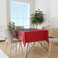 Red floral tablecloth with black eagle design on dining table with four chairs