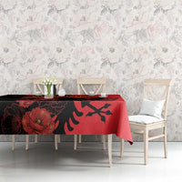 Red and black floral tablecloth featuring eagle emblem, laid across dining table