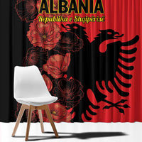 Close-up window curtain with red poppy floral print and black eagle emblem