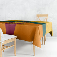 Flag-style tablecloth with orange, teal, and purple panels draped over dining table