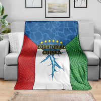 Tri-color Equatorial Guinea flag blanket draped over sofa, stars and blue figure