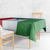 Colorful tablecloth draped on dining set, green and red geometric pattern with blue band