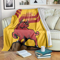 Yellow Spain blanket with red Spanish fighting bull graphic draped over a sofa