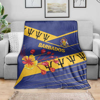 Blue flag-style Barbados blanket on couch with floral design and “BARBADOS” text