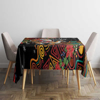 Christmas tablecloth with black base and colorful tribal swirls and poinsettias on dining table