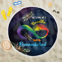 Round beach blanket with navy center, colorful dragonfly design, and white fringe edge