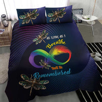 Navy bedding set showing duvet and two pillows with dragonfly and rainbow motif