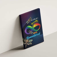 Canvas wall art leaning on wall with rainbow infinity feather and dragonfly embellishments.